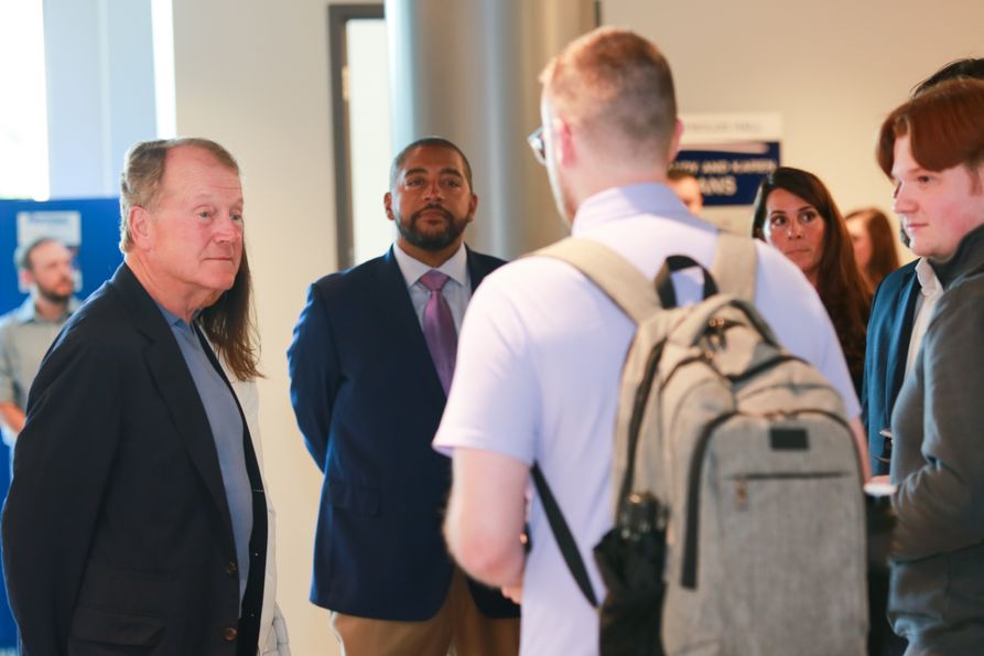 Trilogy Innovations President and CEO Brandon Downey, second from left, joins former Cisco executive chairman and CEO John Chambers, left, in talking to cybersecurity students at West Virginia University.