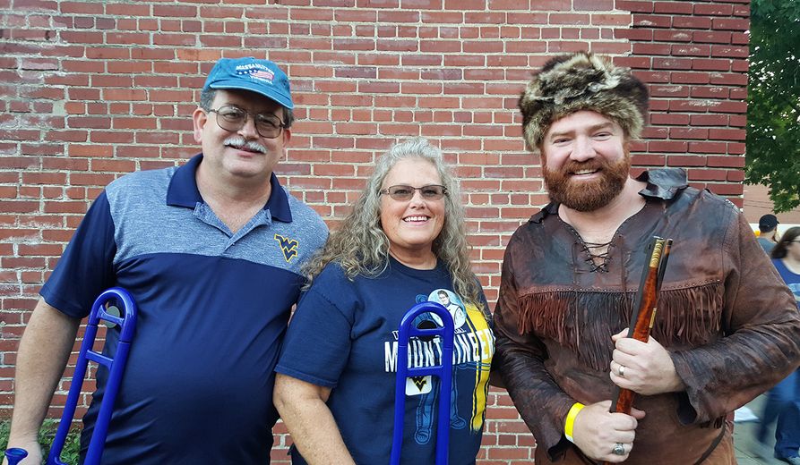 WVU Alumni Band members Don and Amy Hall (from left) pose with former Mountaineer Brady Campbell. 
