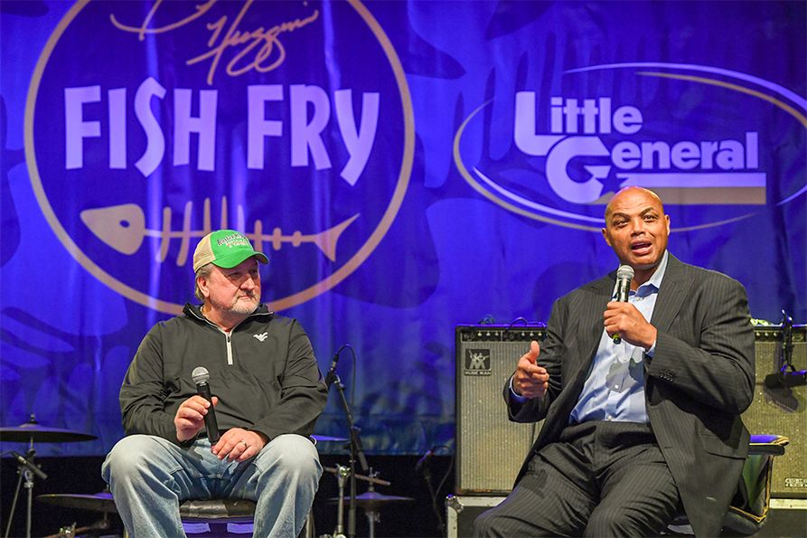 WVU Men’s Basketball Coach Bob Huggins (at left) listens as NBA great Charles Barkley speaks at the 2023 Bob Huggins Fish Fry, presented by Little General Stores. (Photo by Dale Sparks for the WVU Cancer Institute.)