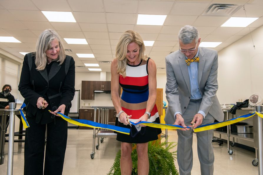 Amy Bircher (center), Beth Shorrock (left) and Darrell Donahue cut the ribbon on the new Amy A. Bircher Textiles Laboratory at West Virginia University.