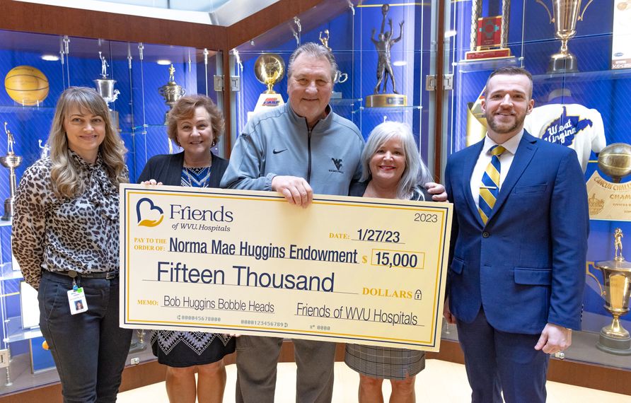 WVU Men’s Basketball Head Coach Bob Huggins (at center) accepts the latest donation to the Norma Mae Huggins Endowment.