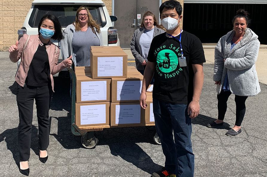 Amy Lin and Jason Wu (wearing masks, from left to right), owners and operators of Fusion Japanese Steakhouse in Morgantown, donate 10,000 medical face masks to WVU Medicine personnel.