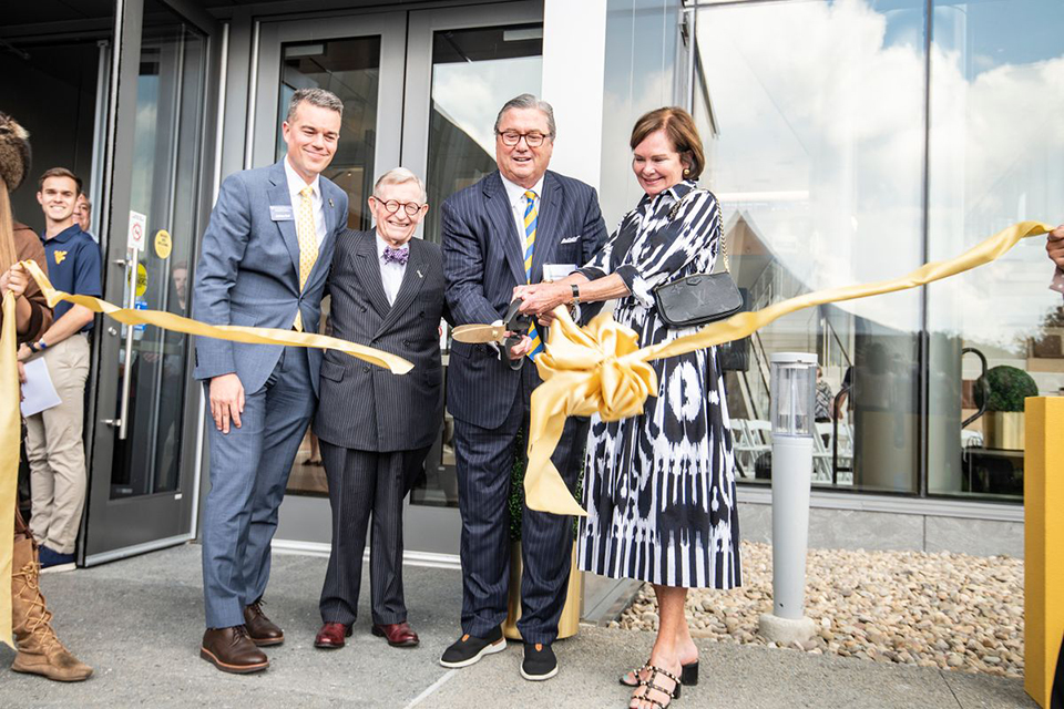 Bob and Laura Reynolds join (from left) Milan Puskar Dean Josh Hall and WVU Gordon Gee in cutting a ribbon to open Reynolds Hall