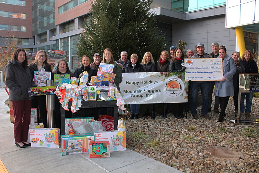 Representatives for the Mountain Loggers Group present a check and toys to administrators and Child Life specialists at WVU Medicine Children's.